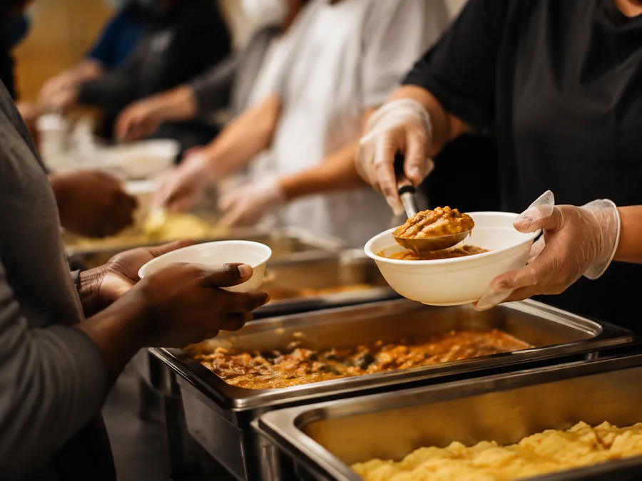 Volunteers serving food to people at a community outreach event